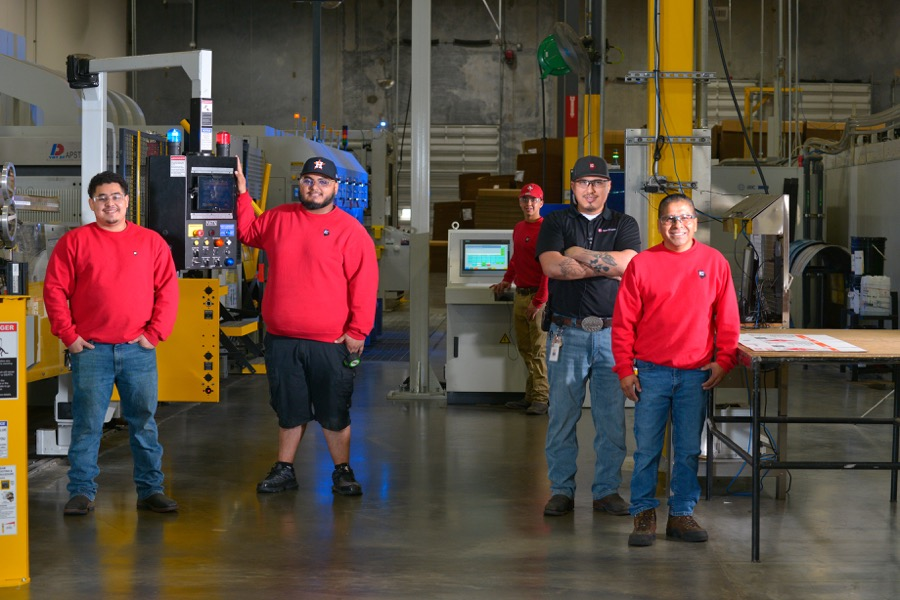 four workers standing on the production floor at BCI.